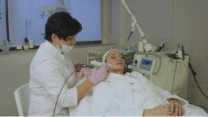A doctor conducting laser hair removal on a female patient